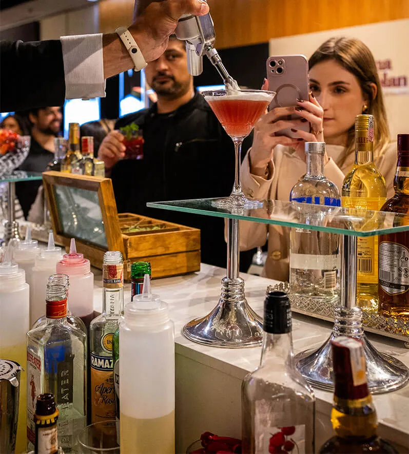 Drinks e Coquetelaria para Casamento - Evento Casar.com Imagem de um drink sendo preparado e uma mulher fotagrafando