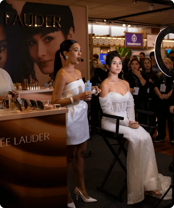 Dia de Noiva e Maquiagem no Evento Casar.com Imagem de uma mulher maquiando uma modelo no evento casar.com no estande da Estee Launder