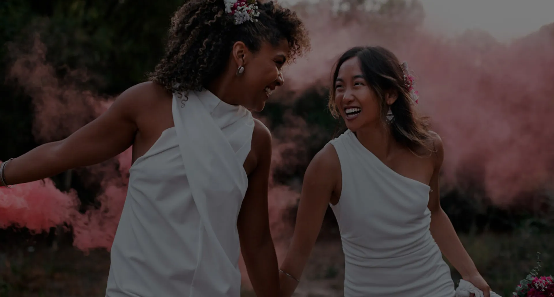 A gente cuida da organização, você cuida do amor. Casal de noivas sorrindo e olhando apaixonadas uma para a outra em seu casamento